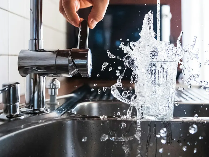 Eau s'écoulant avec force dans un évier en inox