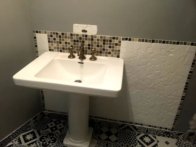 Lavabo sur colonne dans une salle de bains carrelée